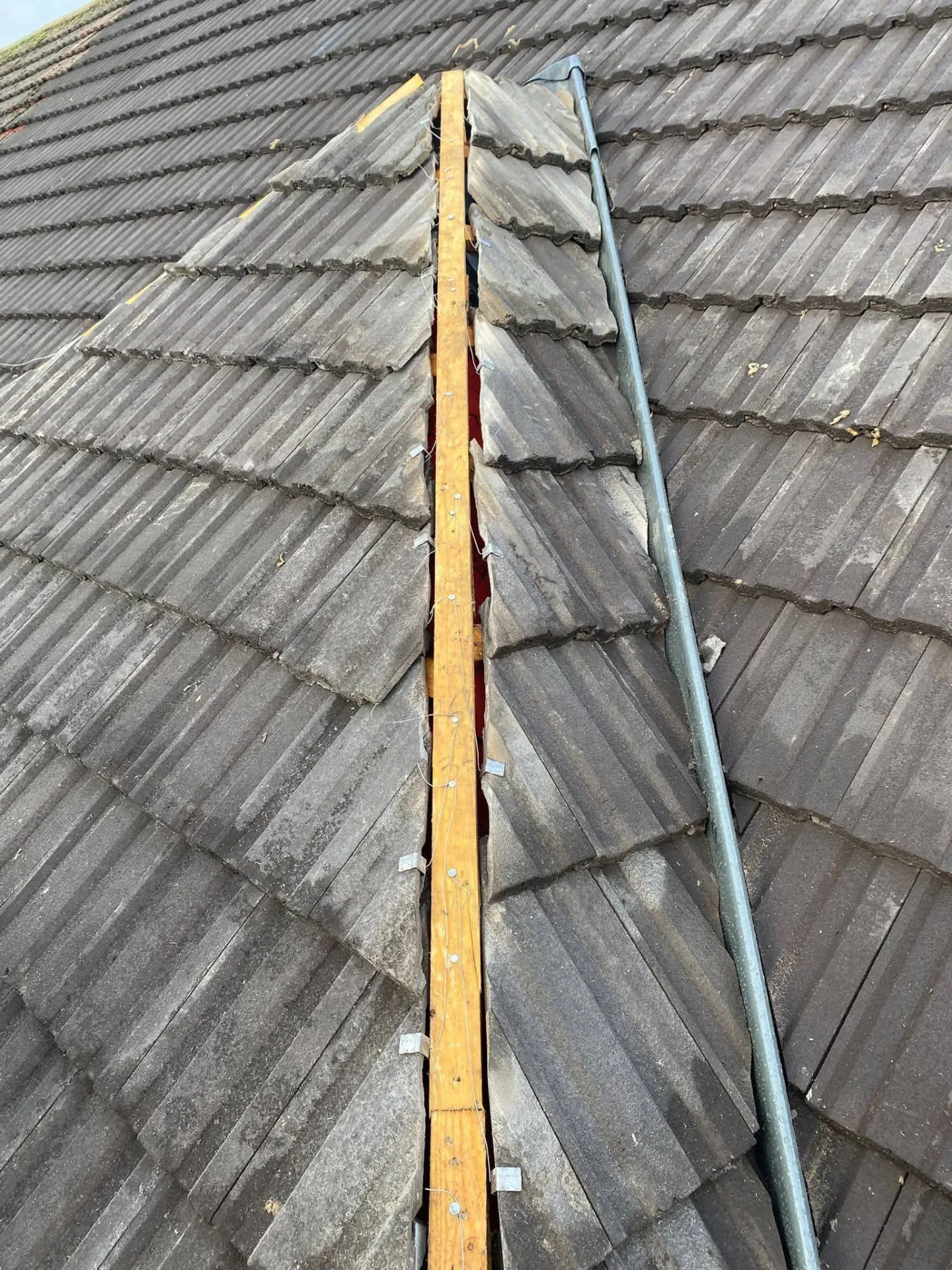 Ridge line with old mortar removed, exposing the timber ridge board before re-bedding
